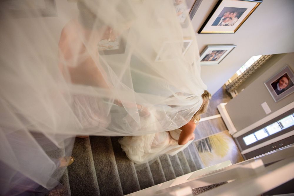 Artistic view of flowing white tulle fabric with framed photos visible in background.