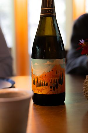 Wine bottles with artistic labels featuring silhouetted landscape designs in warm lighting.