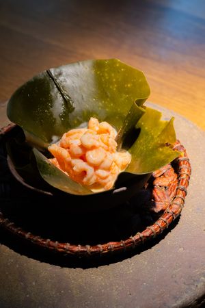 Fresh salmon tartar served on a dark plate with green garnish.