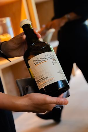 Wine bottle being displayed in soft focus with label visible.