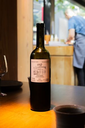 Wine bottle with vintage label displayed on wooden table in warm lighting.