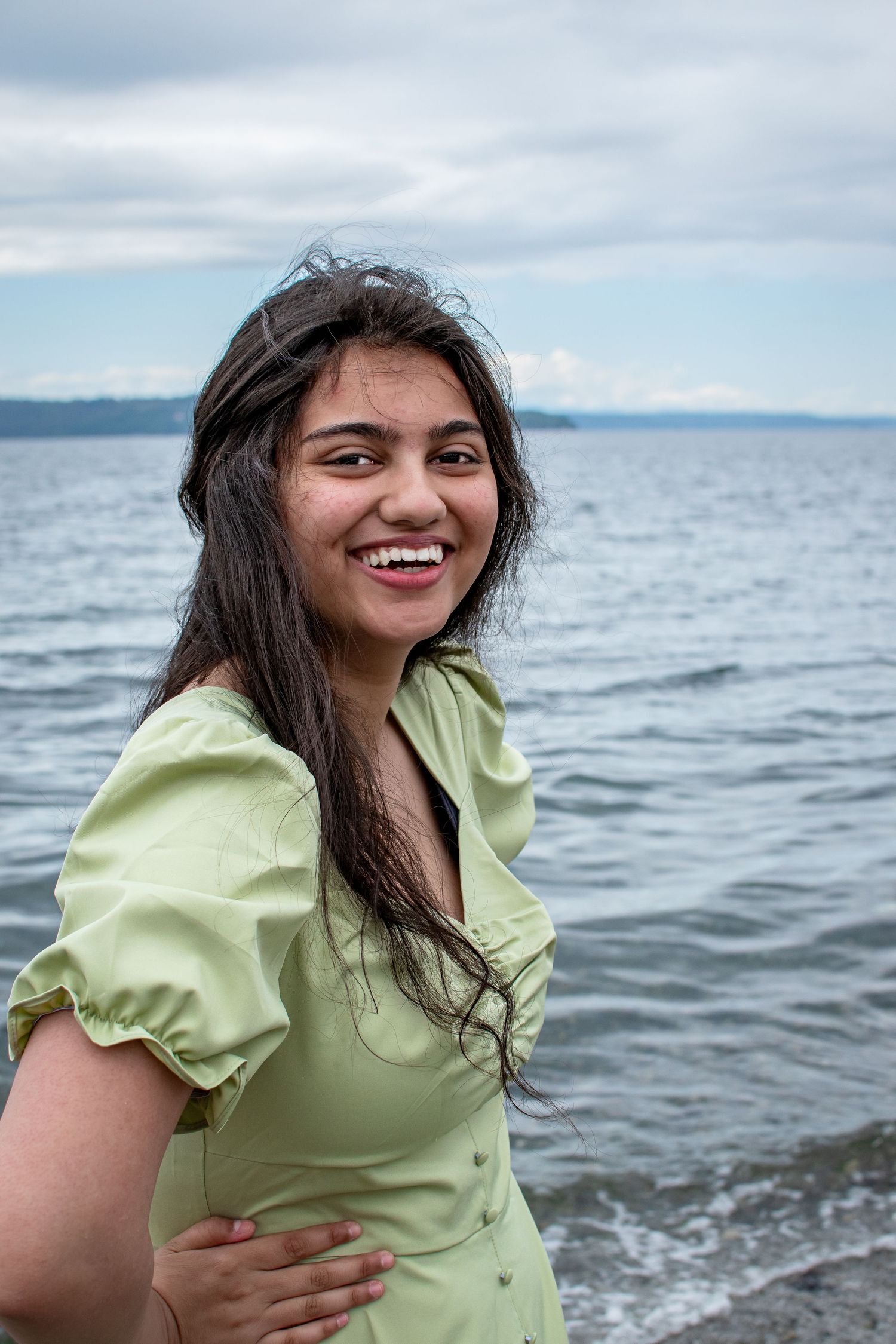High school senior laughing naturally during portraits in Seattle with guidance on posing.