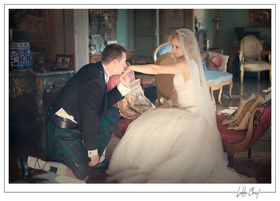 Romantic moment of Scottish groom kneeling and kissing bride’s hand at Château de Pouget, South of France destination wedding photography