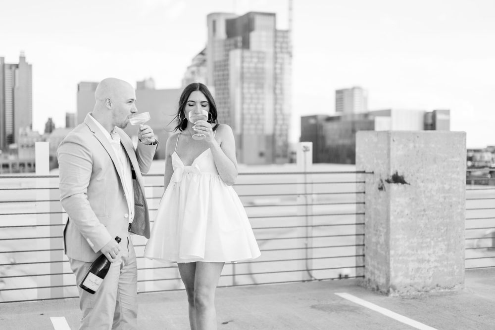Urban rooftop engagement session with city skyline backdrop.