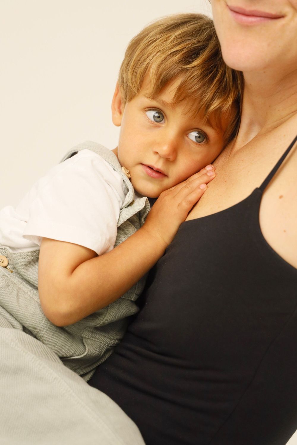 A series of four connected photos showing a child resting against someone wearing a black tank top.