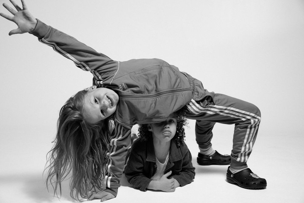 Energetic studio portrait showing a child in sporty attire doing a playful dance move