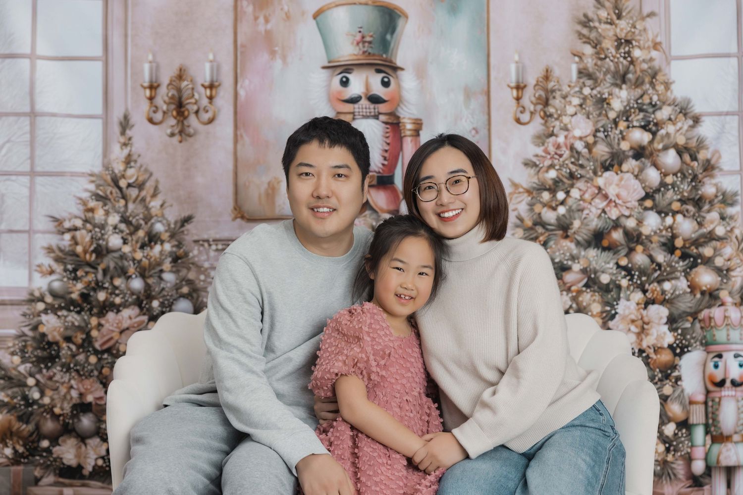 Family poses together in front of decorated Christmas trees in a series of holiday photos.