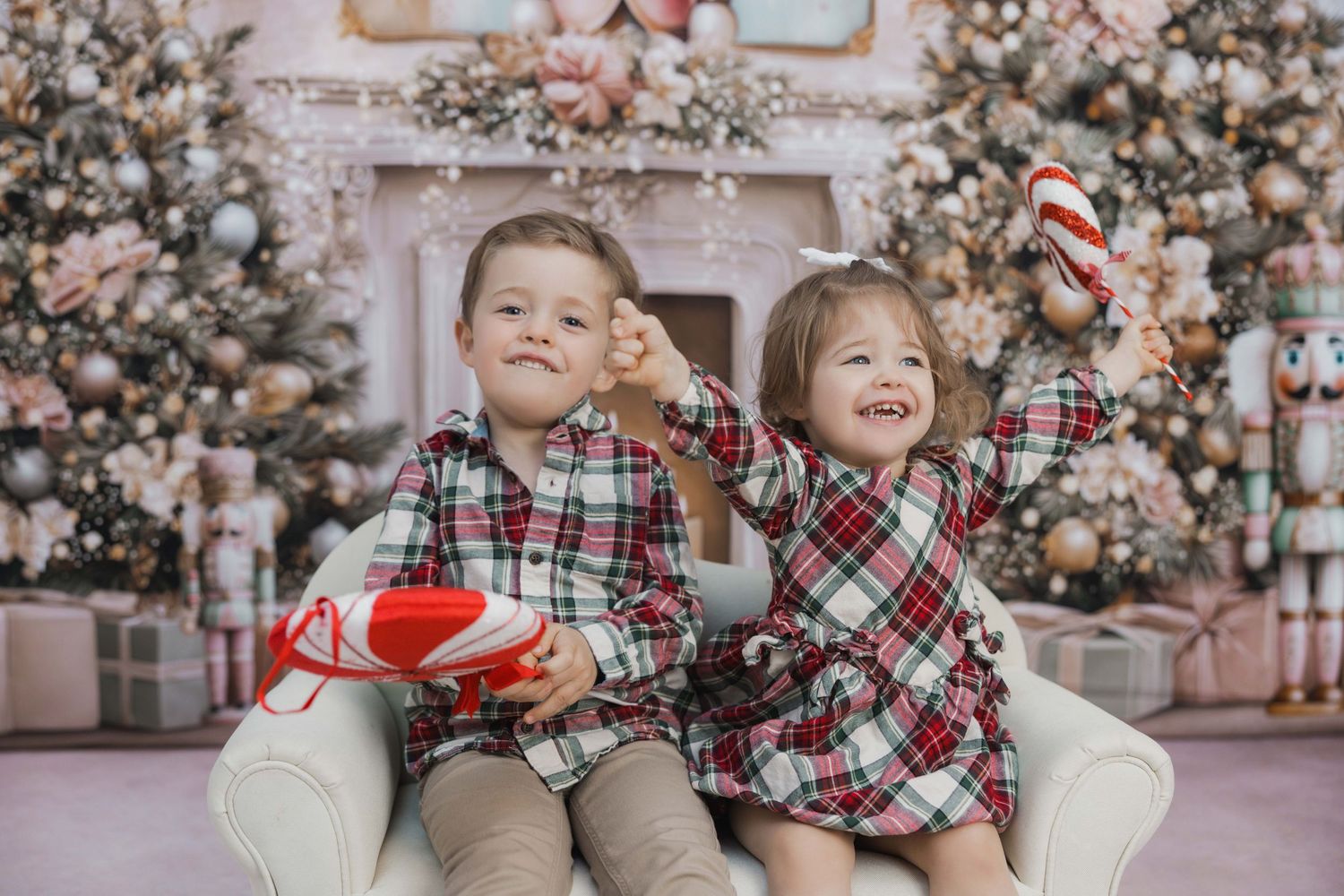 Holiday scene with plaid outfits and festive decorations against a pink and gold Christmas backdrop.