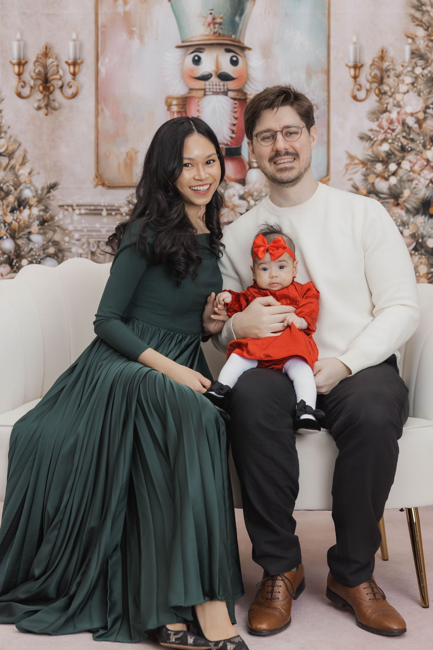 Four connected holiday photos show a couple in green dress and white shirt posing together with a baby in festive attire.