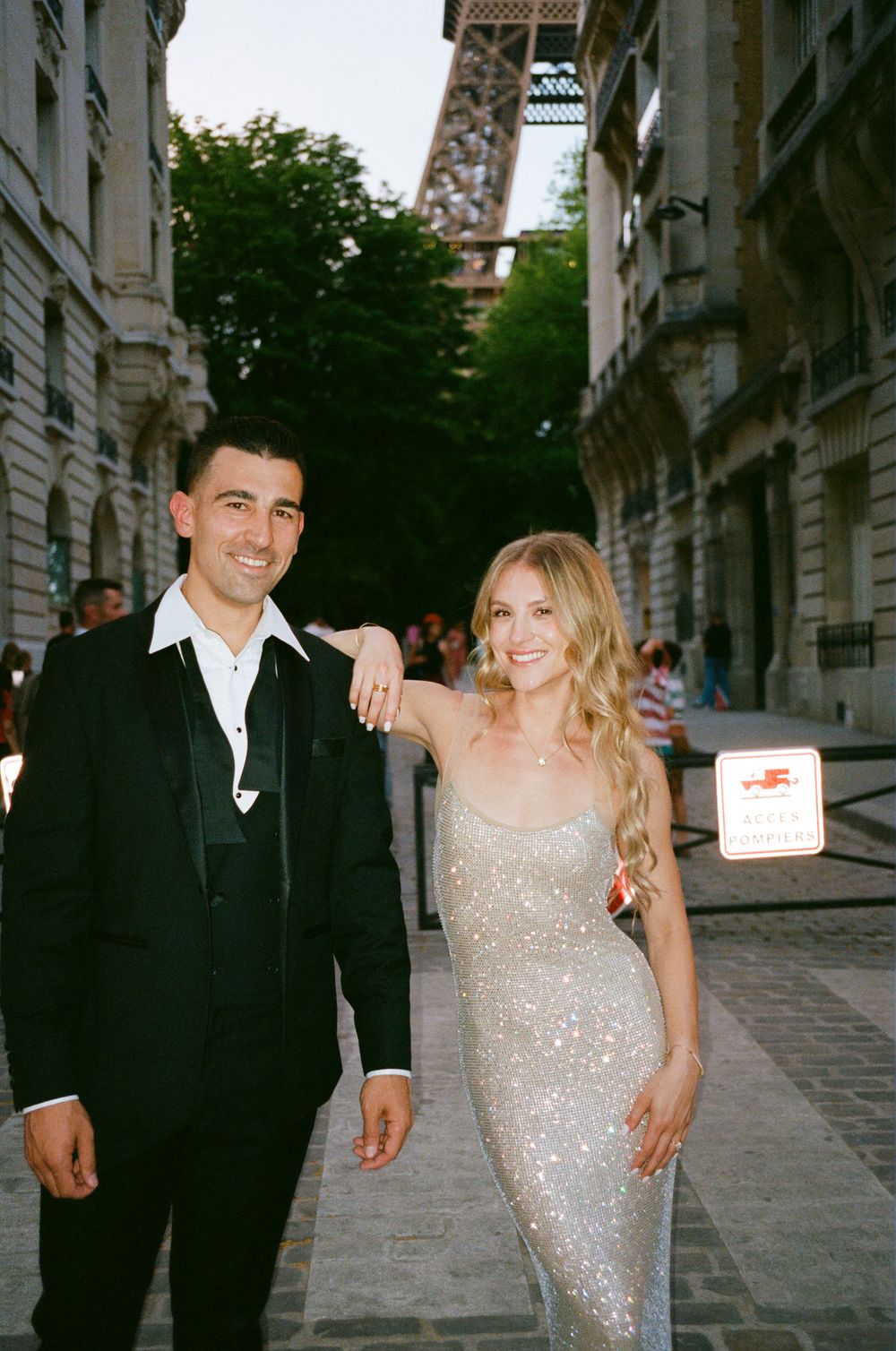 Couple in formal attire poses together on a romantic Eiffel tower sparkle. Stylish paris couple in front of eiffel tower, paris nighttime