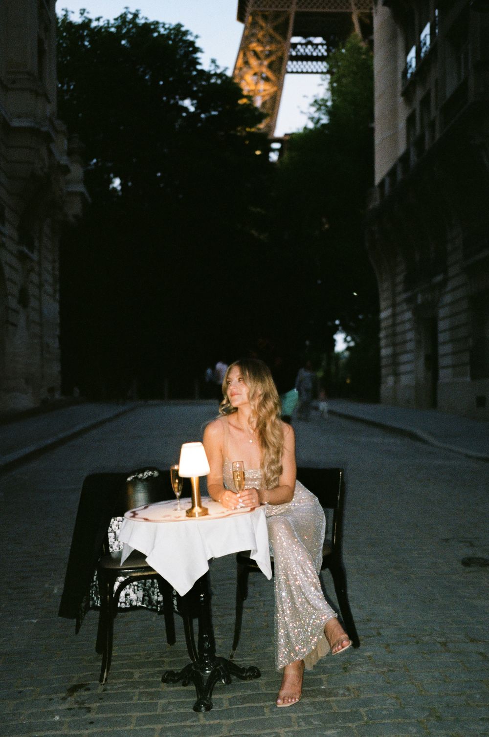 Sitting in street in sparkly dress in Paris with eiffel tower at night behind, paris film photoshoot, paris film photographer
