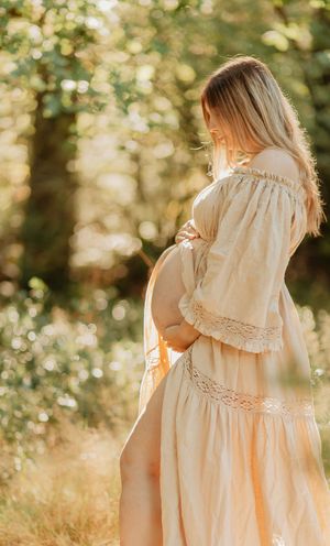 A series of dreamy photos showing a person in a flowing cream-colored vintage dress walking through sunlit woods.