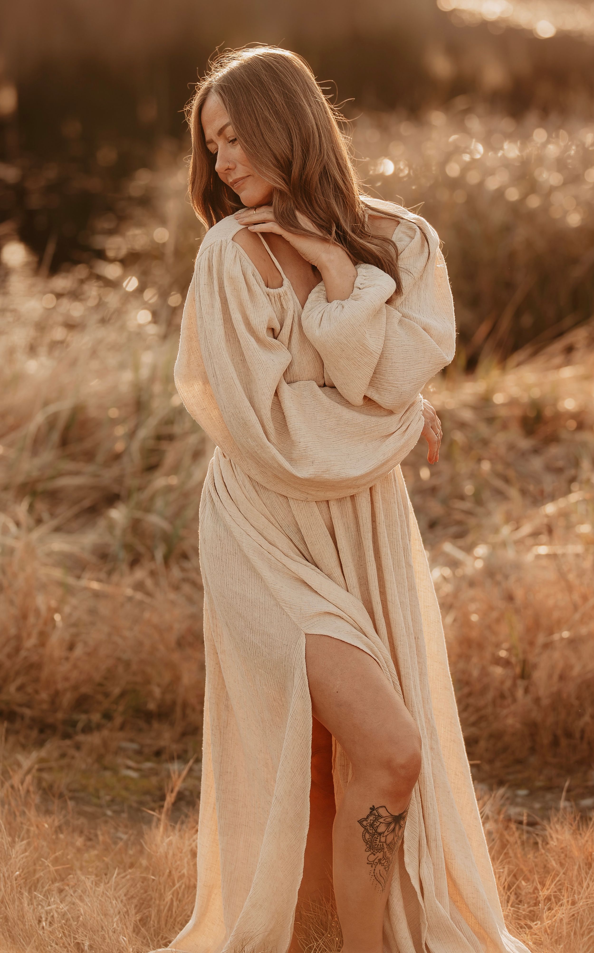 Artistic boudoir photography featuring flowing fabric and natural lighting in sepia tones.