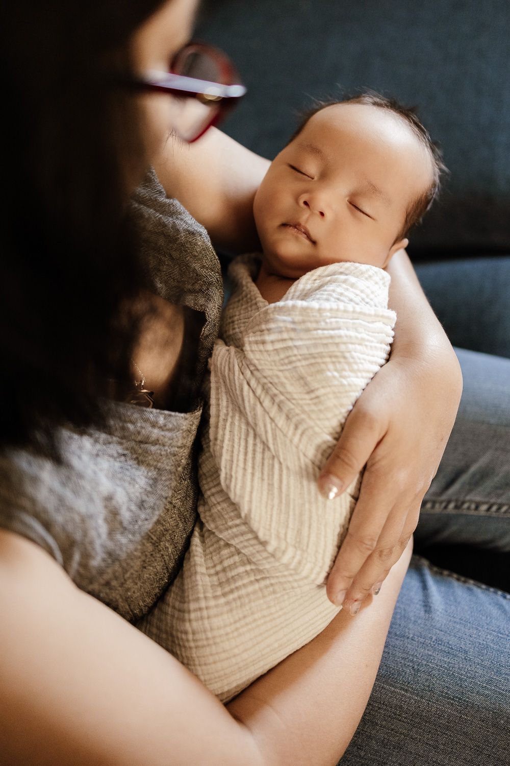 Close-up of mom holding her new baby near window light