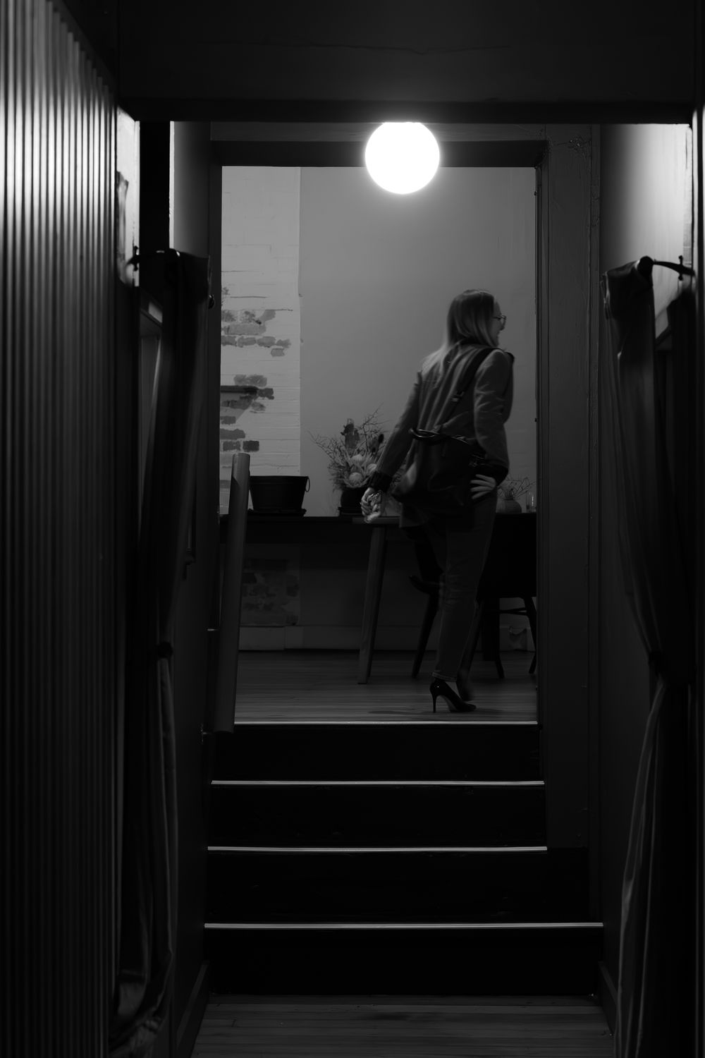 Black and white photo series showing a dimly lit hallway with a circular light and dark shadow silhouettes.