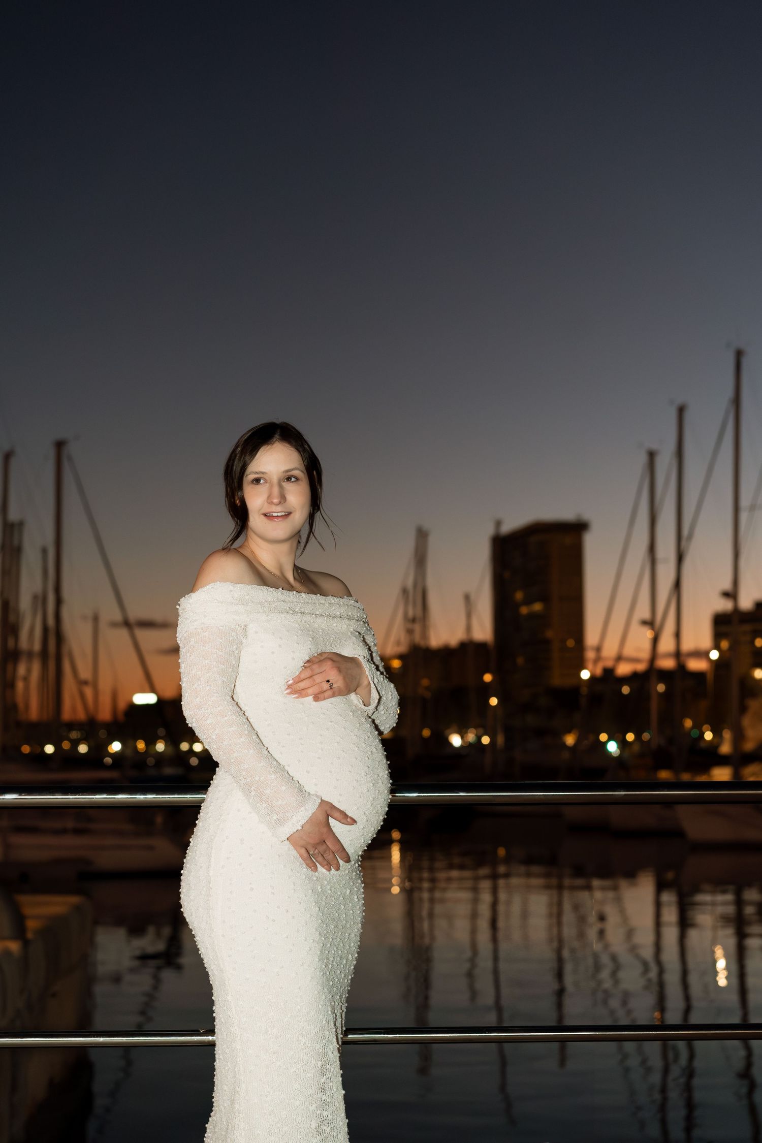 Nocna sesja ciążowa w hiszpańskim porcie. Przyszła mama celebruje chwile.