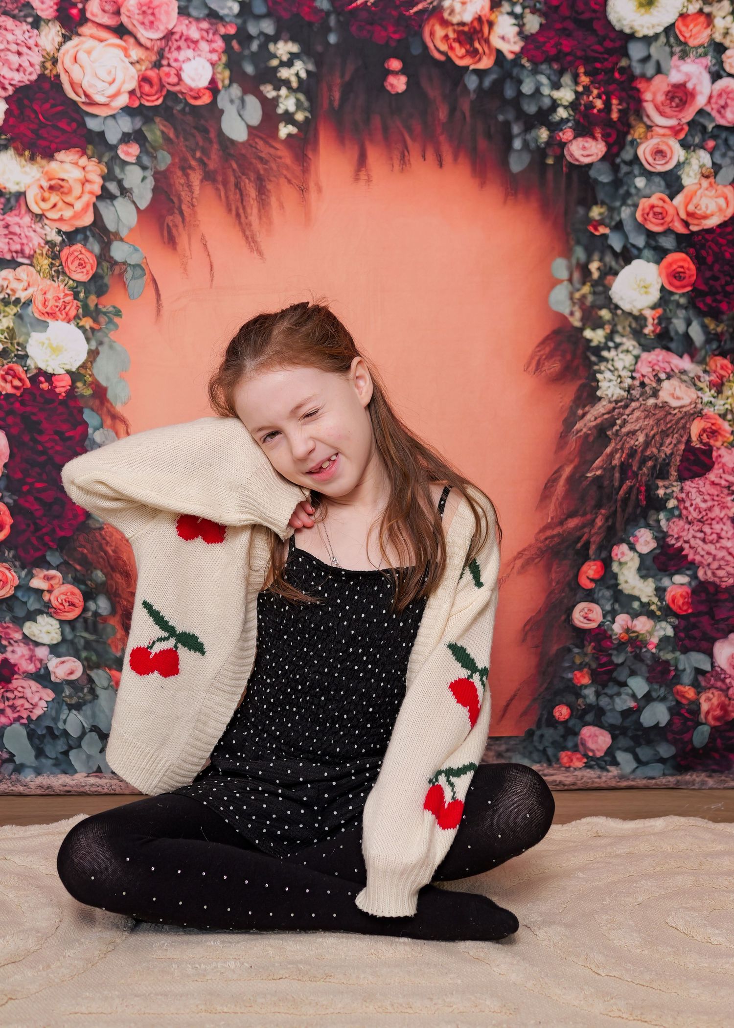 A cozy photoshoot against a floral backdrop with coordinated outfits.