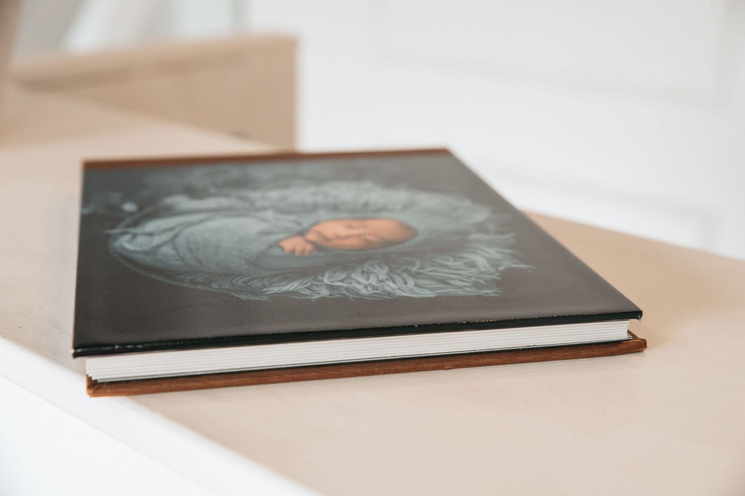 Elegant photo album displayed at various angles on white surface showing cover design.