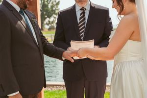 An intimate outdoor wedding ceremony moment with a couple holding hands during their vows.