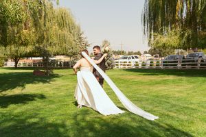 Green lawn for an outdoor wedding ceremony with weeping willow trees creating a natural backdrop.