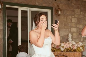 Wedding reception scene at a rustic stone venue with white tablecloths and warm lighting.
