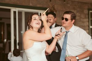 Wedding reception guests enjoying a candid party moment with beverages and laughter at an outdoor venue.