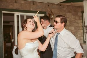 Wedding couple and guests having fun dancing together at an indoor reception venue.