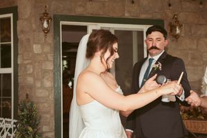 Wedding couple shares a joyful dance moment on a brick patio during their evening reception celebration.