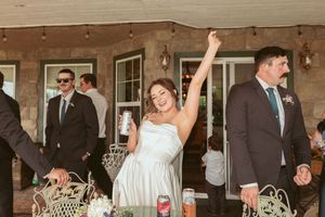A wedding celebration at a porch venue with people in formal attire enjoying a lively reception moment.