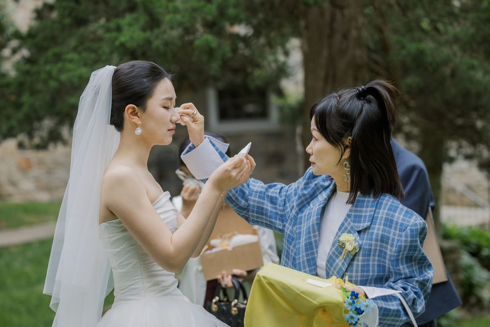 Candid moment shared between bride and guest during outdoor wedding celebration.