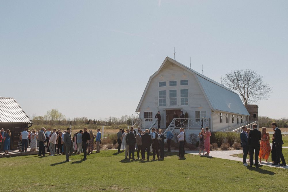 Panoramic view of a white church and grounds during a wedding celebration.