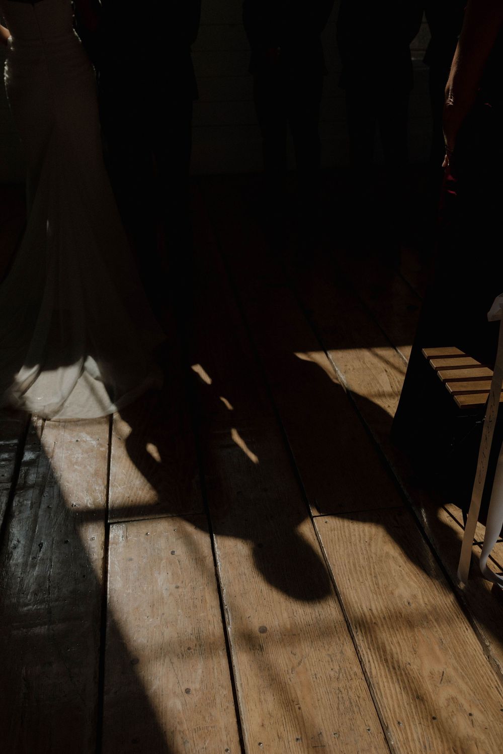 Dramatic shadows cast on wooden floorboards during an indoor event.