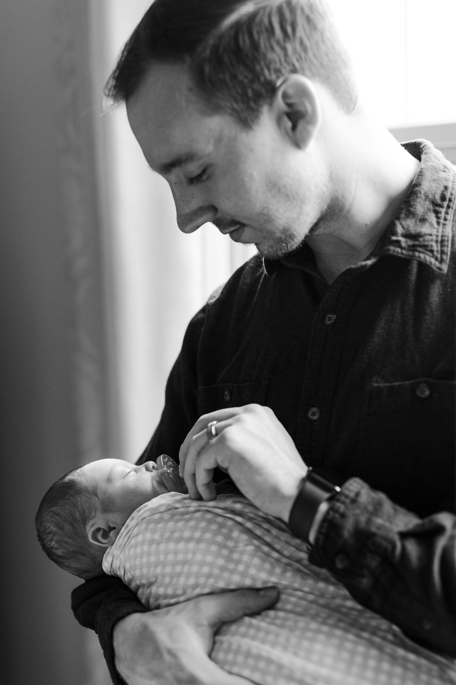 Black and white photo of a father holding his newborn son