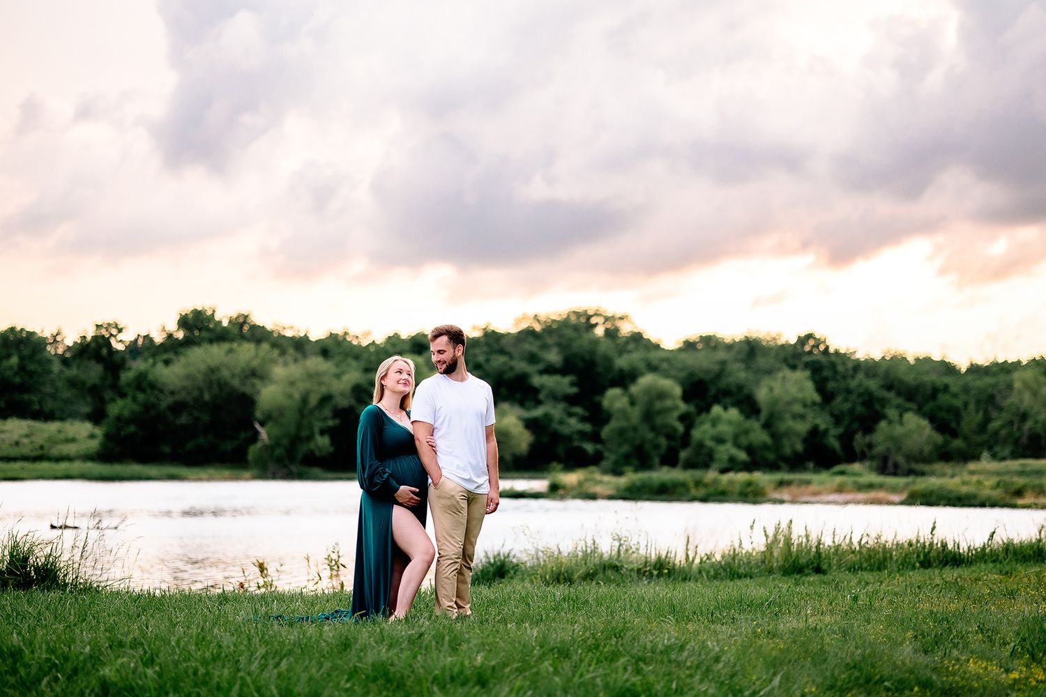 outdoor maternity photoshoot in lee's summit. couple posed near a pond at sunset