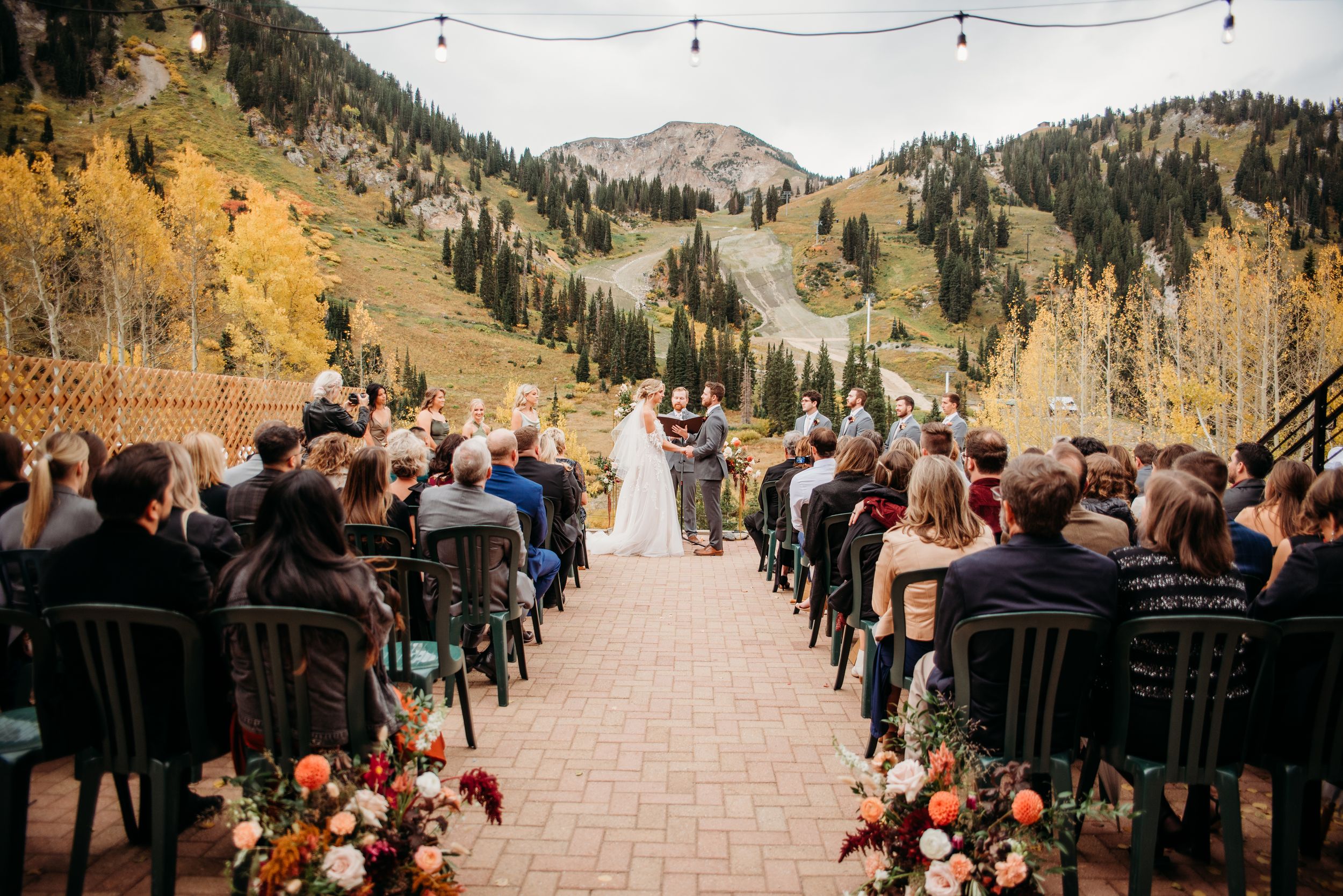 Outdoor wedding ceremony setup at a scenic mountain venue with golden fall foliage in the background.