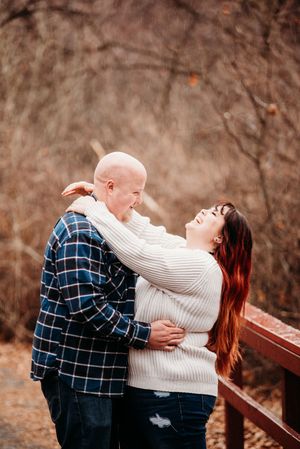 Romantic couple sharing a joyful moment outdoors wearing cozy sweaters on an autumn day.