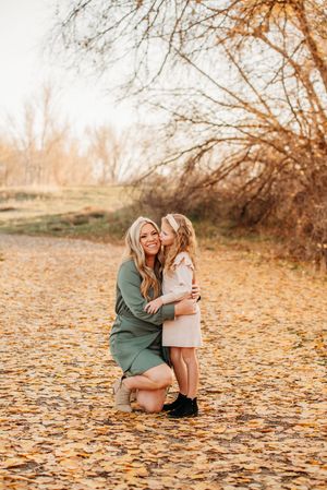 Heartwarming autumn scene with fallen golden leaves on ground as a tender embrace is shared in nature.
