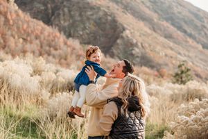 Couple spending quality time together outdoors in autumn mountain landscape with tall dry grass and warm lighting.