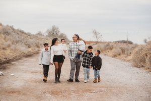 Desert landscape gathering with people in casual clothing standing together on a dirt road.