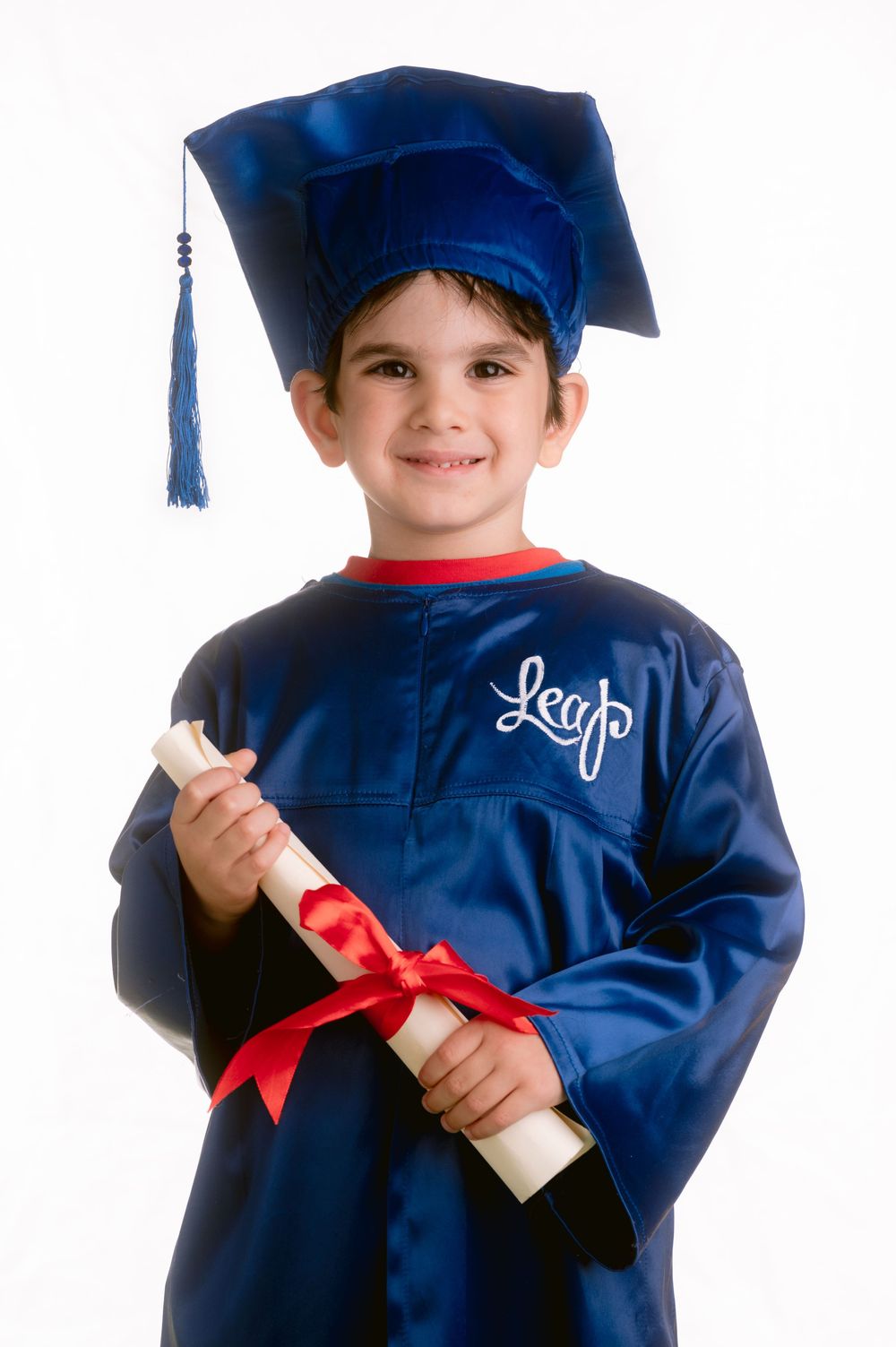 Child in royal blue graduation gown and cap holds rolled diploma with red ribbon.
