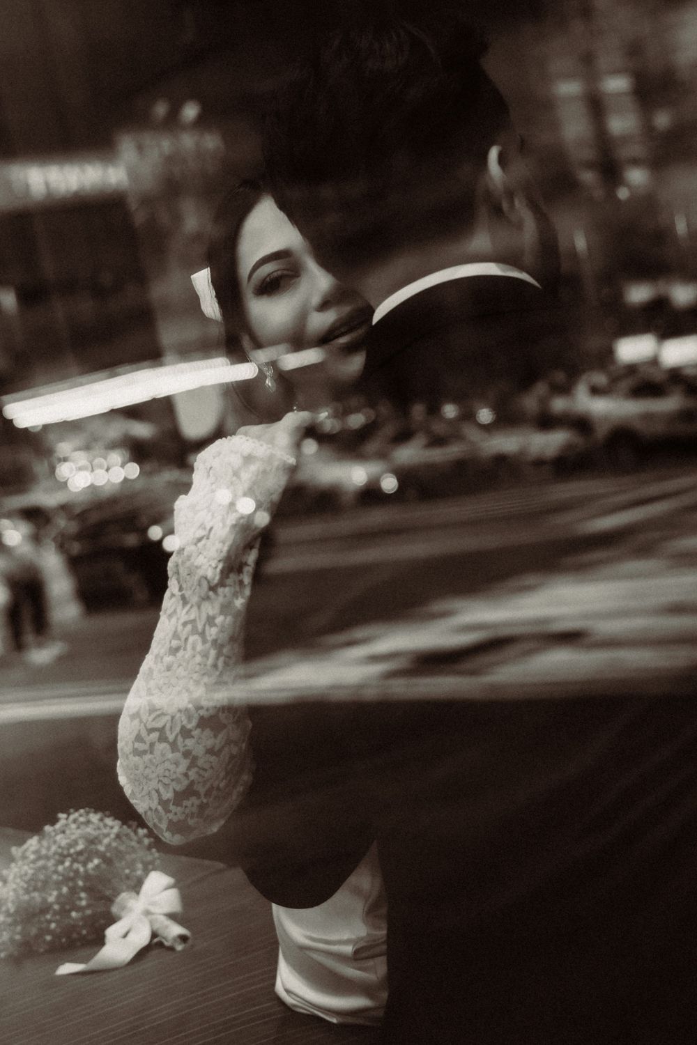 Artistic black and white sequence showing a dancer's graceful sideways leap against a blurred city backdrop at night.