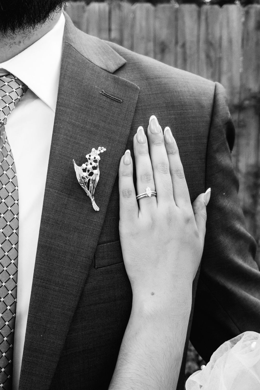 Black and white wedding photo series showing close-up details of rings and formal attire.