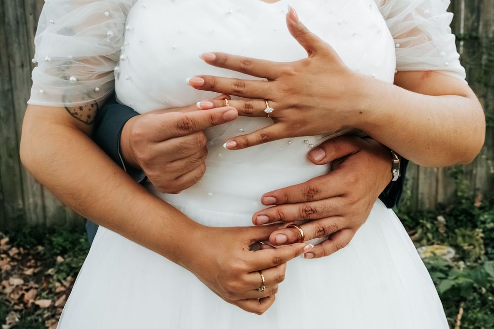 Close-up series of hands holding a white ceramic vase against a wooden fence backdrop.