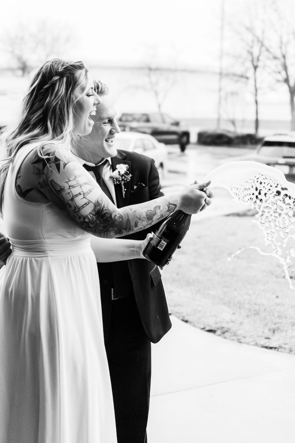Joyful moment spraying champagne at wedding celebration.