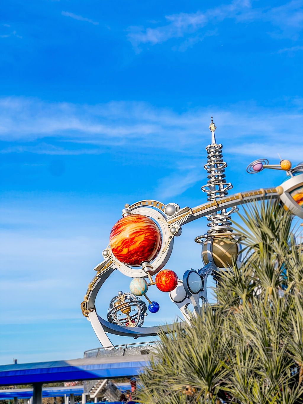 A dynamic sequence of metal sculptures depicting a musical performer with a red guitar against a bright blue sky.