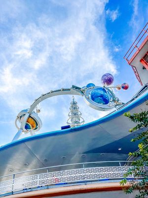 Retro-futuristic architectural details of Tomorrowland at Disneyland with curved metal beams against blue sky.
