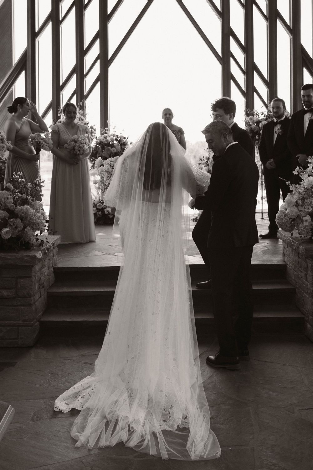 A wedding couple dancing in a wooden pavilion with natural light streaming through the windows.