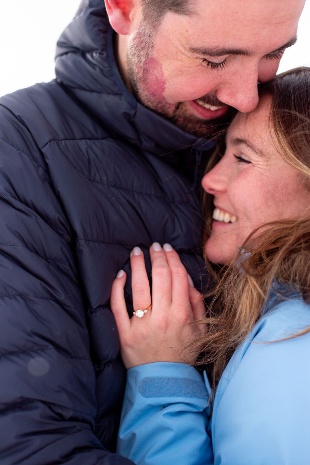 A joyful engagement moment captured with the ring visible between the happy couple.