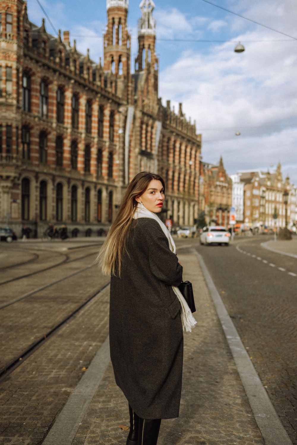 Gothic architecture of historic buildings along a cobblestone street in Amsterdam.
