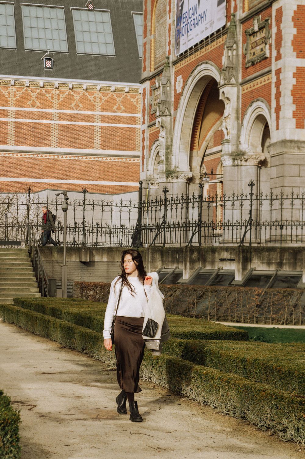 Architectural fashion shoot outside a grand historic building with ornate iron fencing.